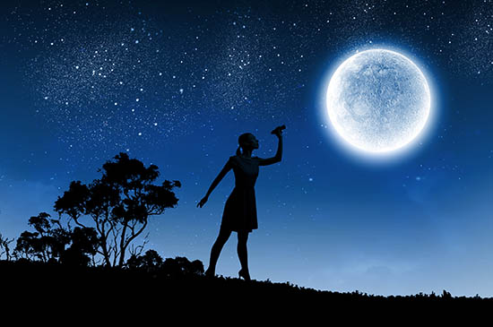 Woman pointing at the moon with a blue background