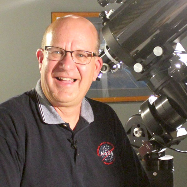 Billy Hix standing next to a telescope