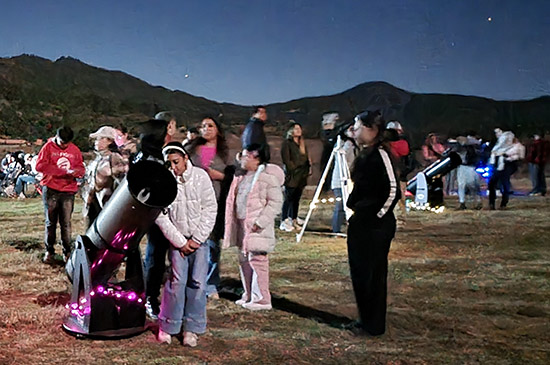 Photograph of families looking through telescopes at night